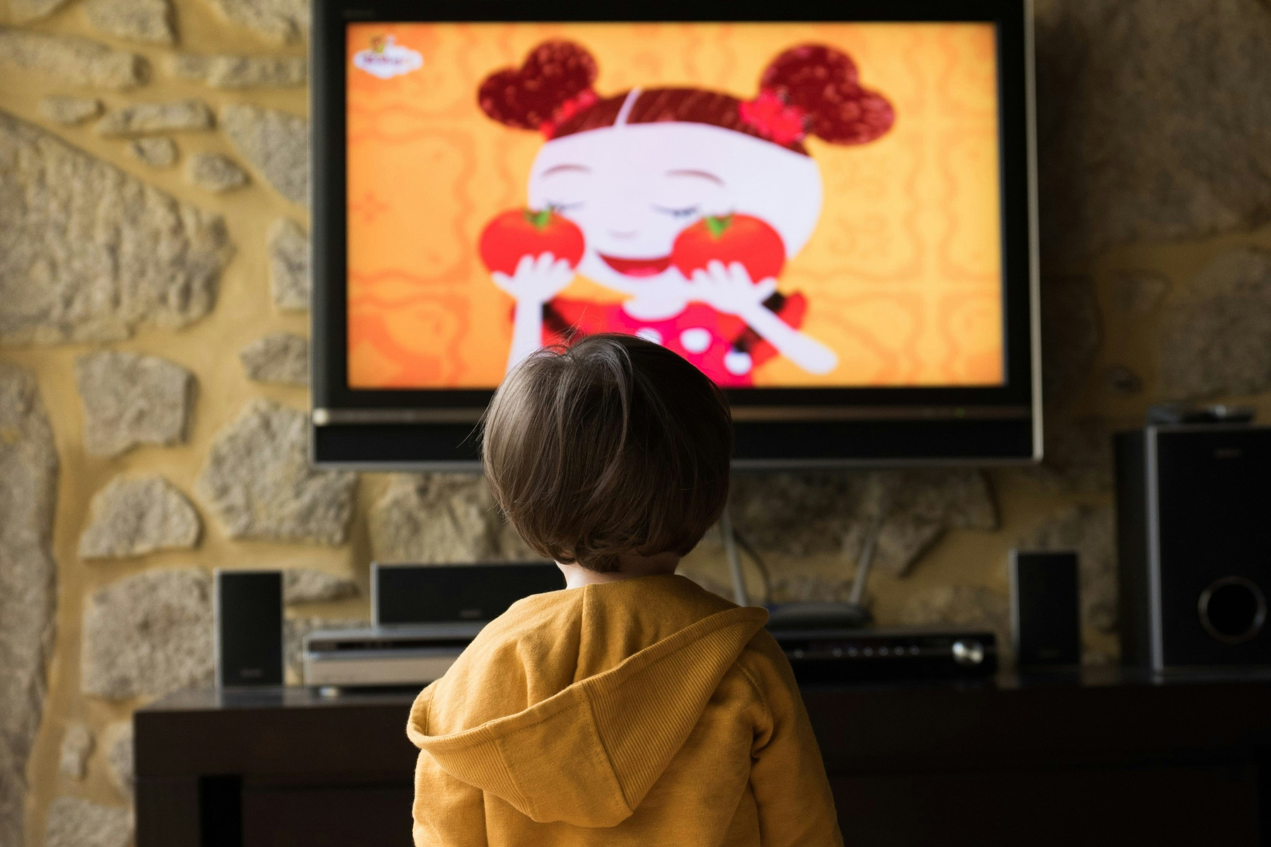 Kind vor dem Fernseher im Wohnzimmer